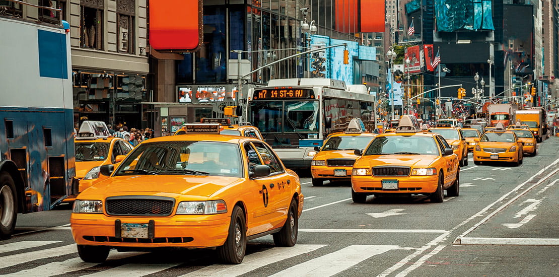 Famous yellow taxi cabs driving through New York, USA